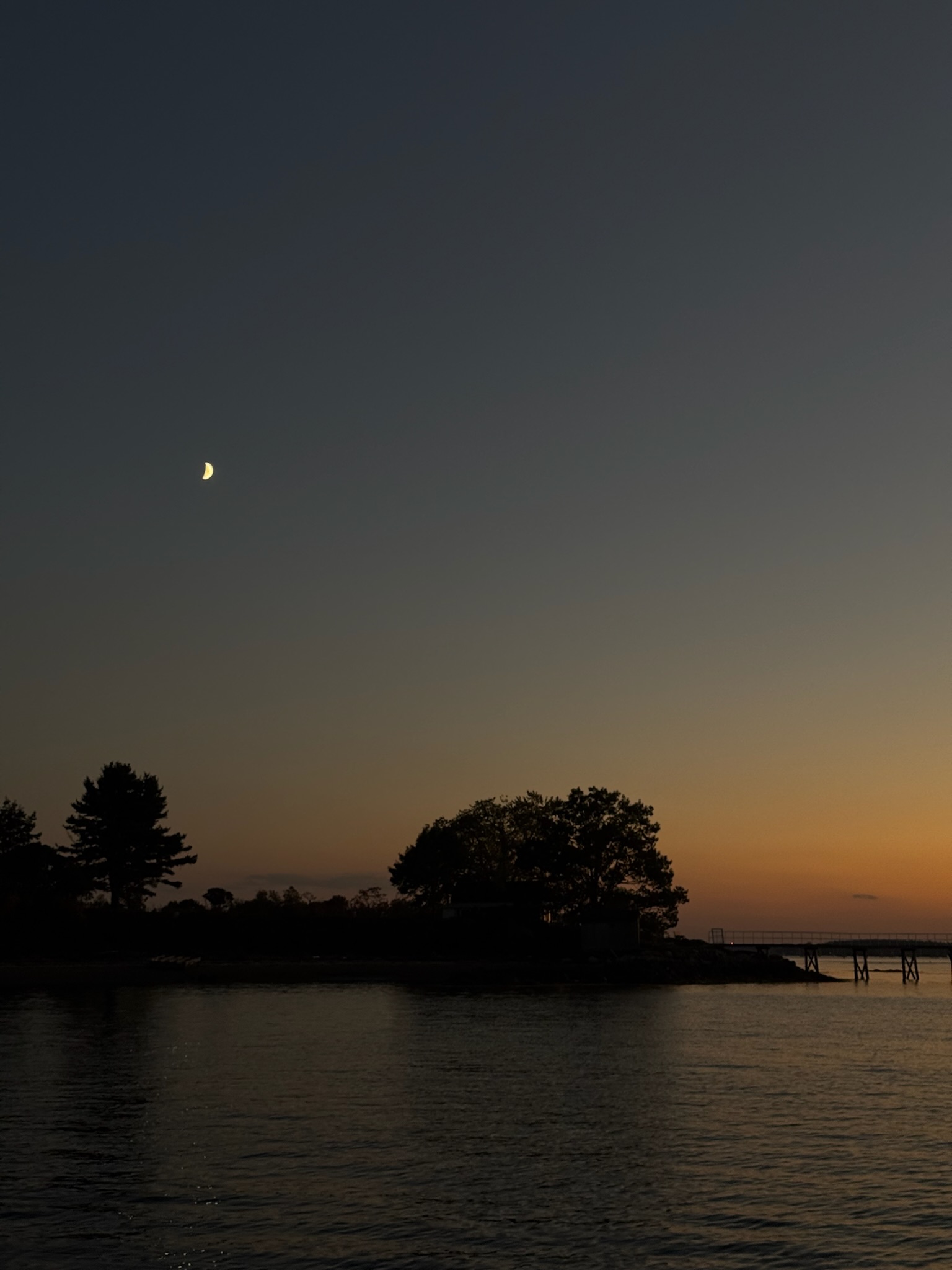Island silhouette with crescent moon at dusk